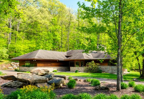 A house near Malvern, PA with a garden and surrounded by trees on a summer day.